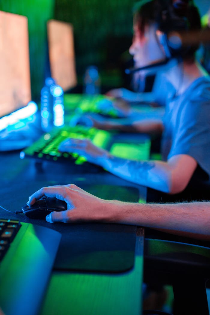Team of gamers focused on screens during an intense online gaming session.